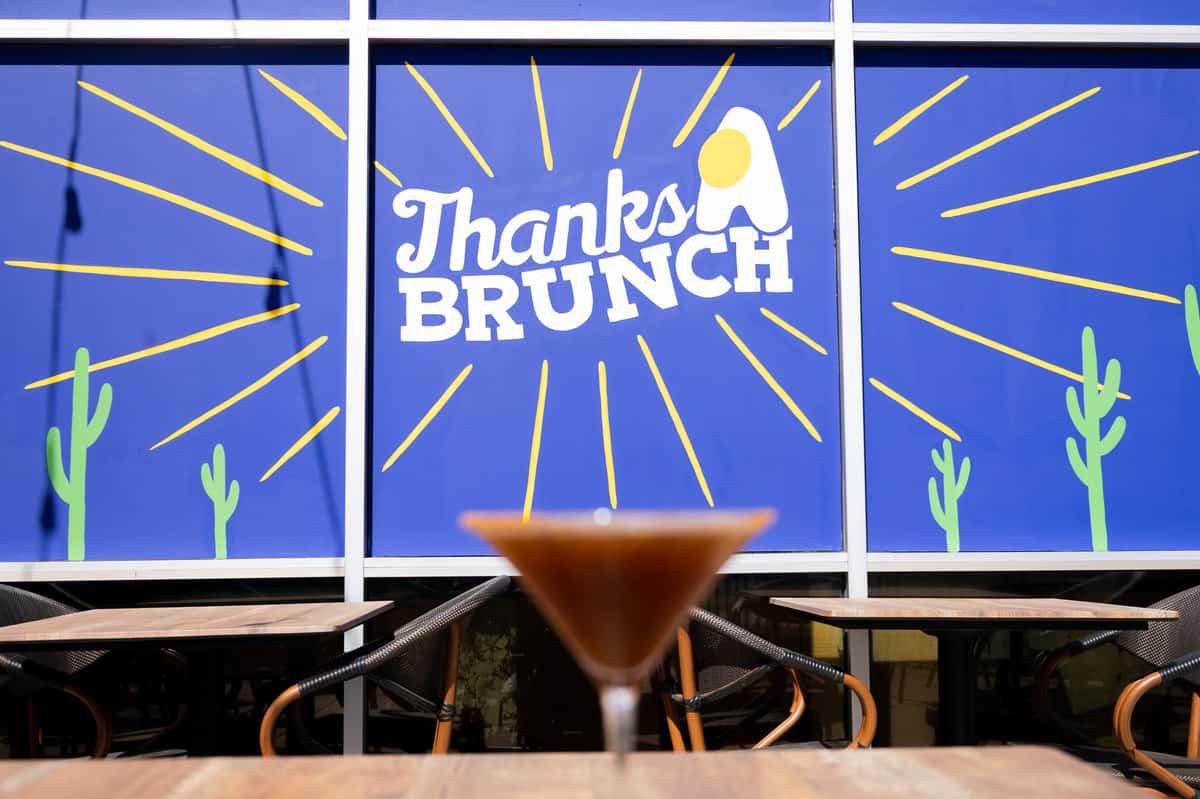 A wall mural featuring white line art and the "Thanks Brunch" logo against a blue background.