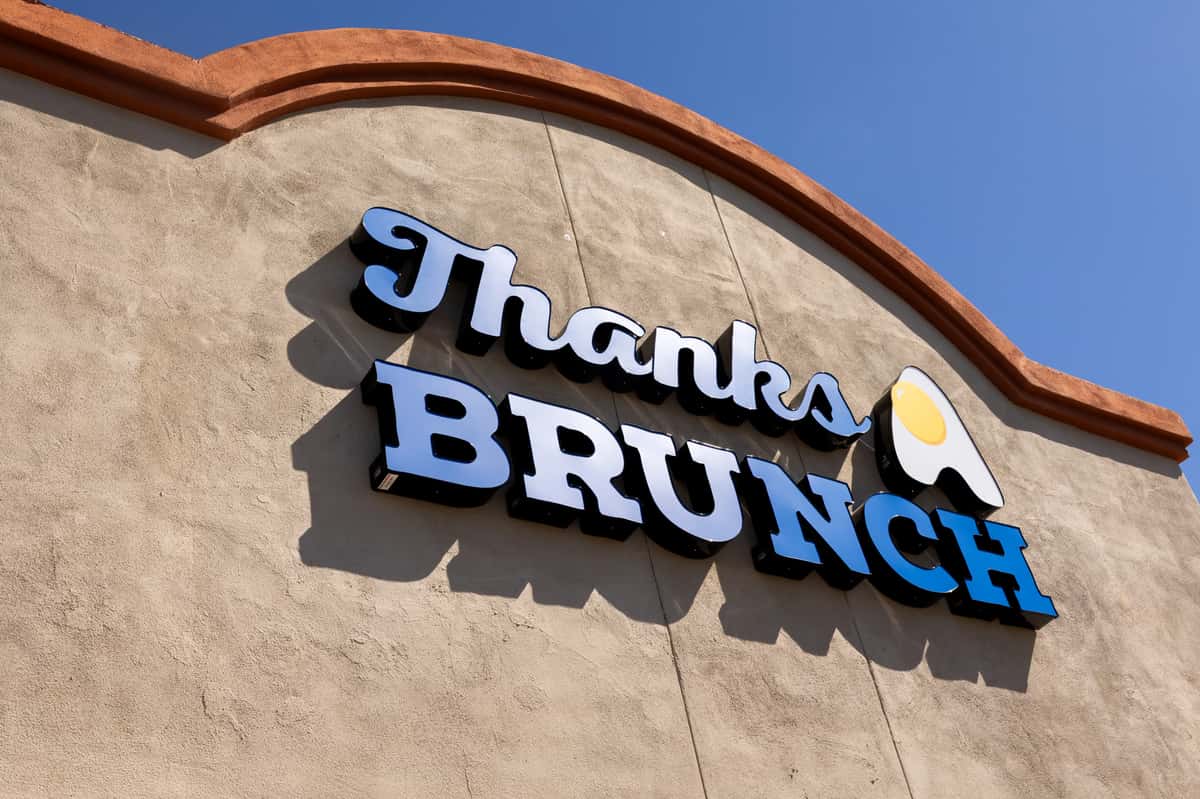A view of the restaurant's exterior featuring a 3D "Thanks Brunch" sign on the facade.