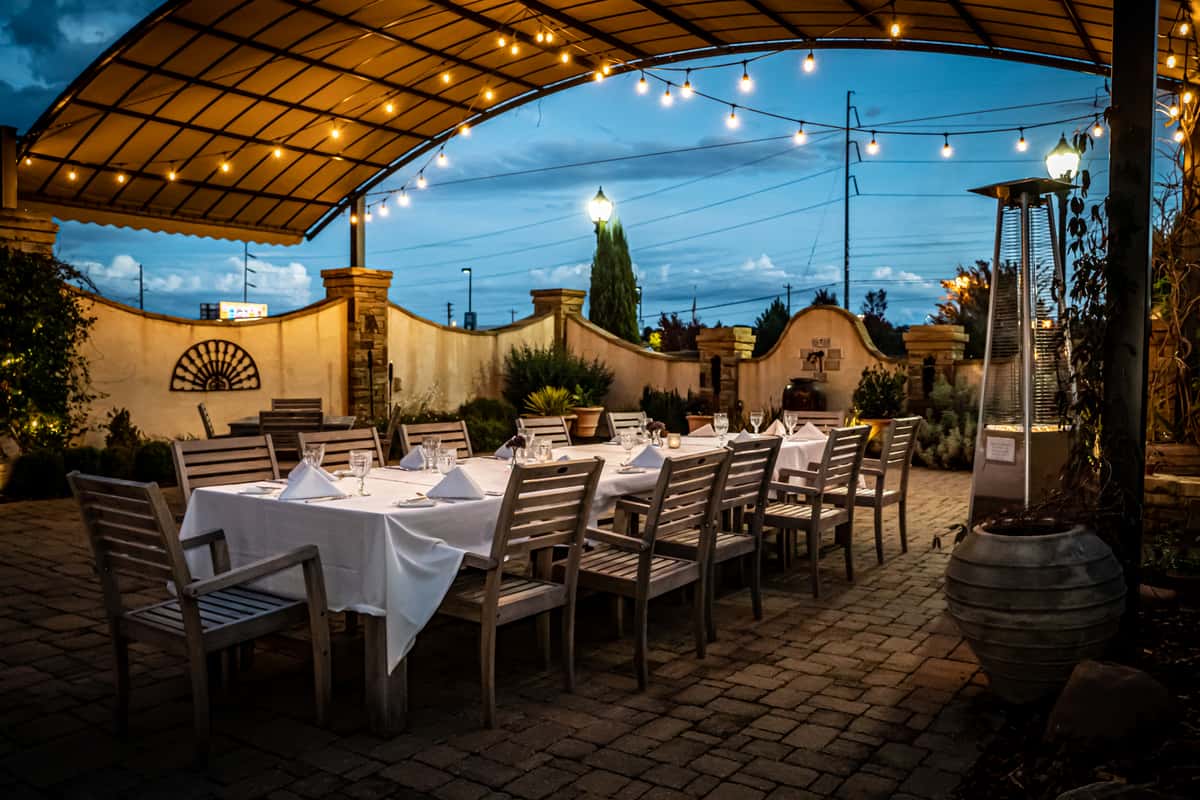Outdoor dining area with tables, chairs and hanging lights