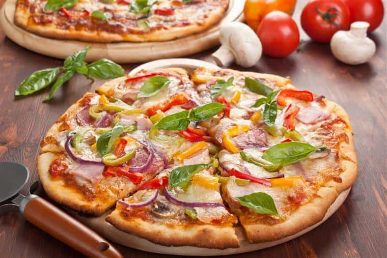 Pizza pie with vegetables on wood table