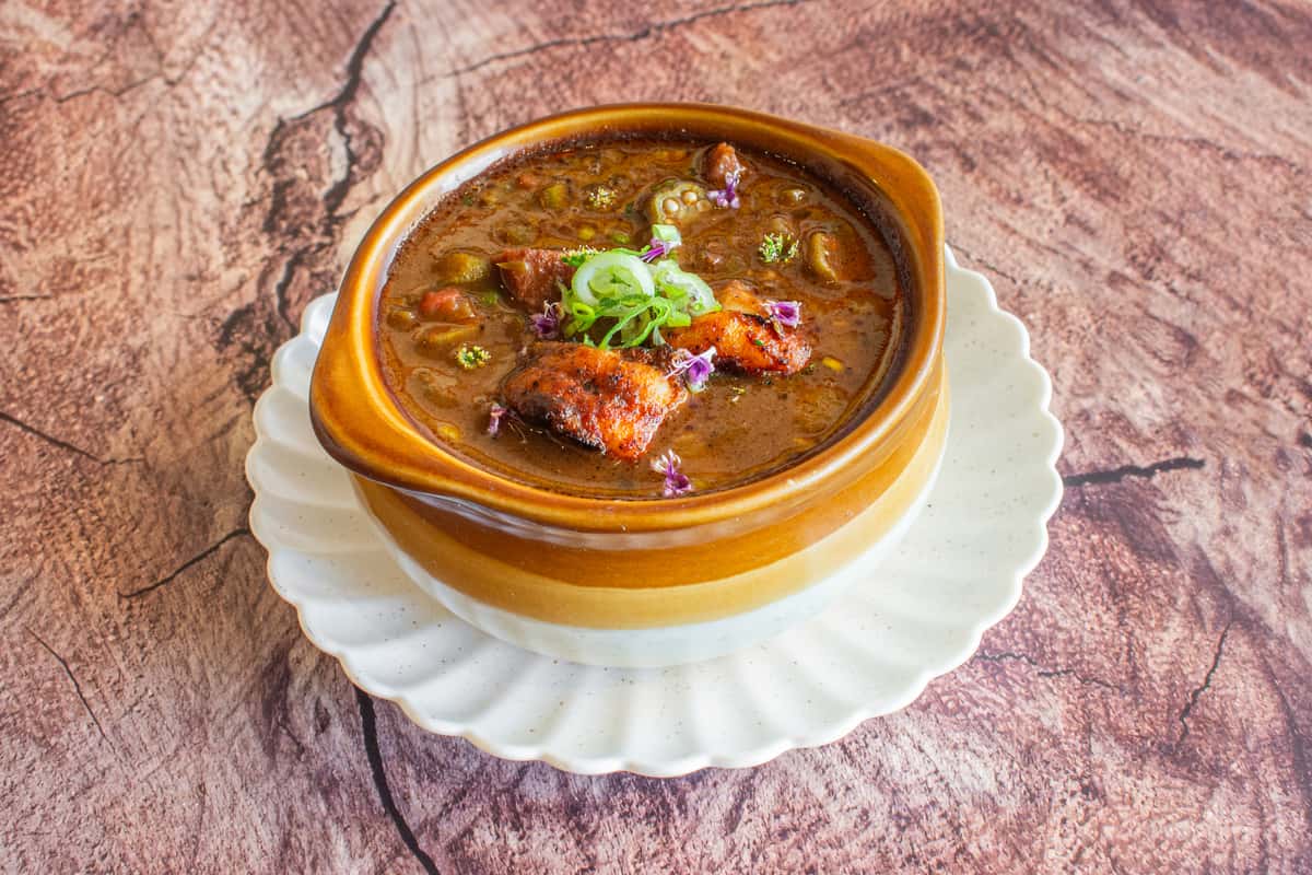 A hearty bowl of traditional gumbo filled with shrimp, sausage, and tender vegetables in a rich, dark roux-based broth. Garnished with fresh herbs, this comforting Southern classic delivers bold Cajun flavors and a warm, satisfying dining experience.