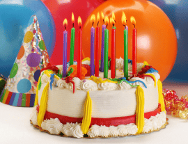 birthday cake with several different colored candles lit