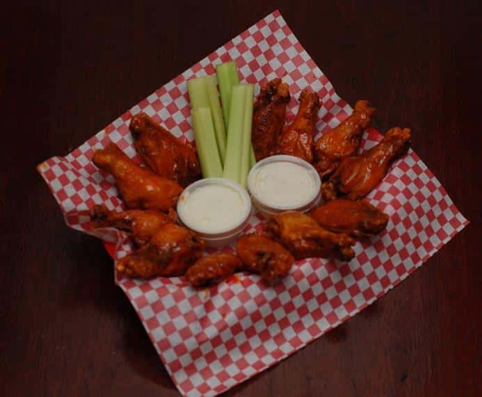 Chicken wings with blue cheese in a basket with carrots, cellery and bleu cheese