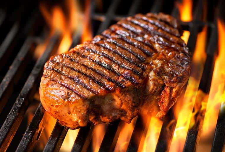 Thick steak on fire grill