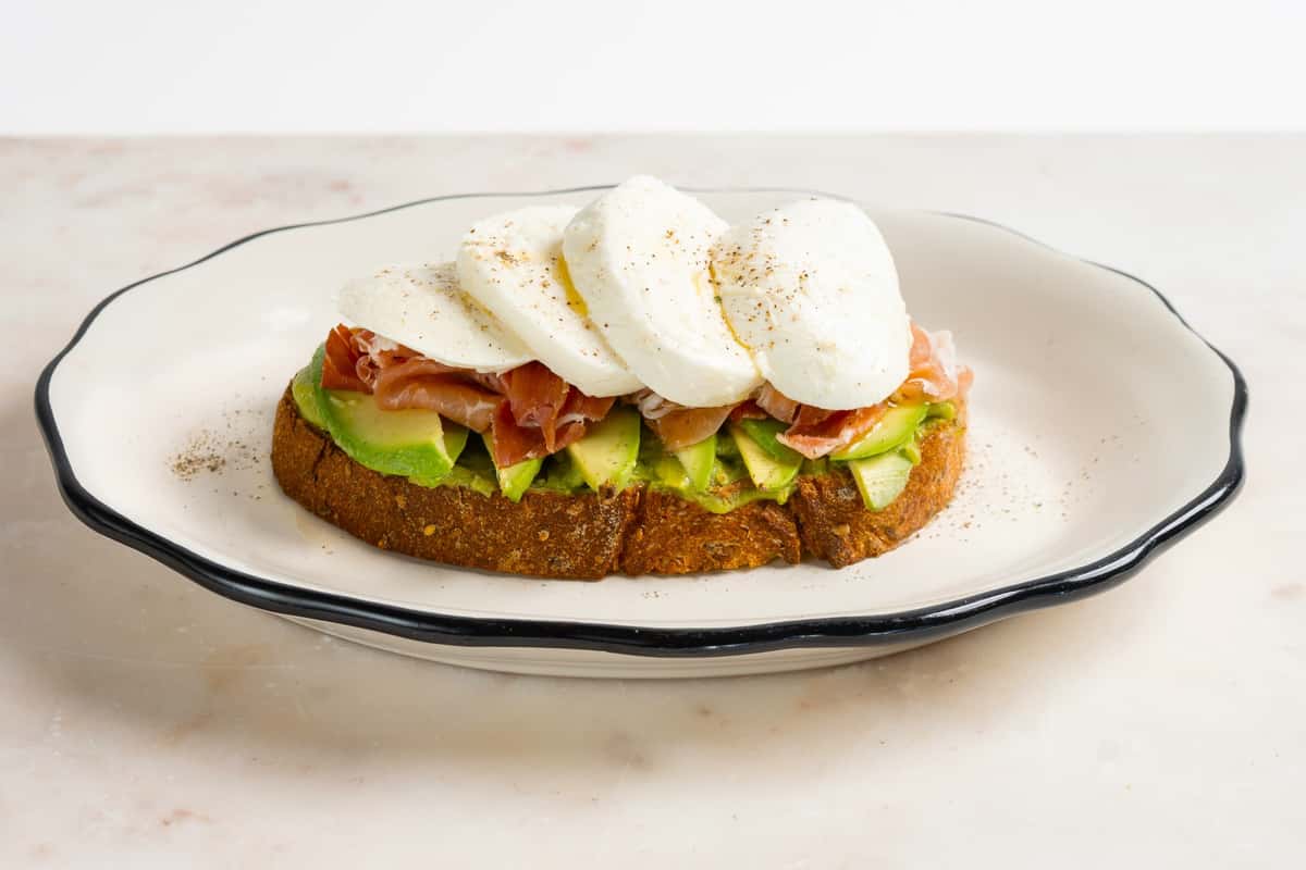 Toasted Bread, Avocado Spread, Prosciutto, Mozzarella Cheese, Black Pepper, drizzled with Olive Oil.