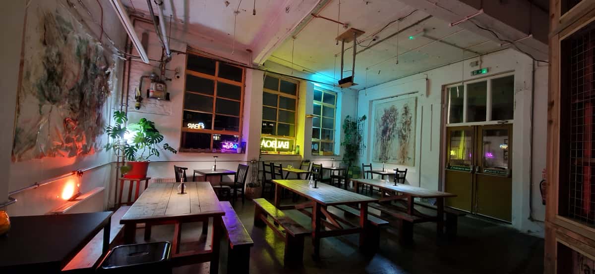 Dining room with long tables and colorful lighting along the walls