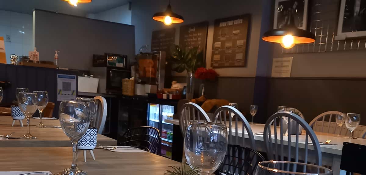 Restaurant interior with a counter area, chairs, and warm hanging lights