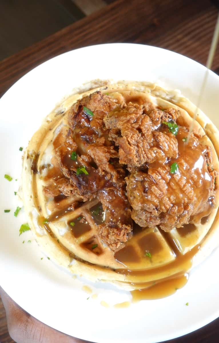 waffle and chicken with sauce on top