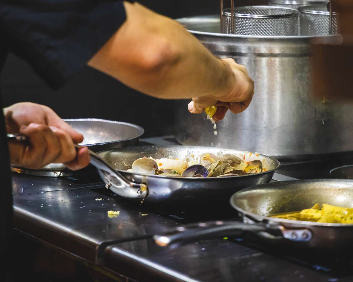 Chef creating dishes on a stove with fresh ingredients