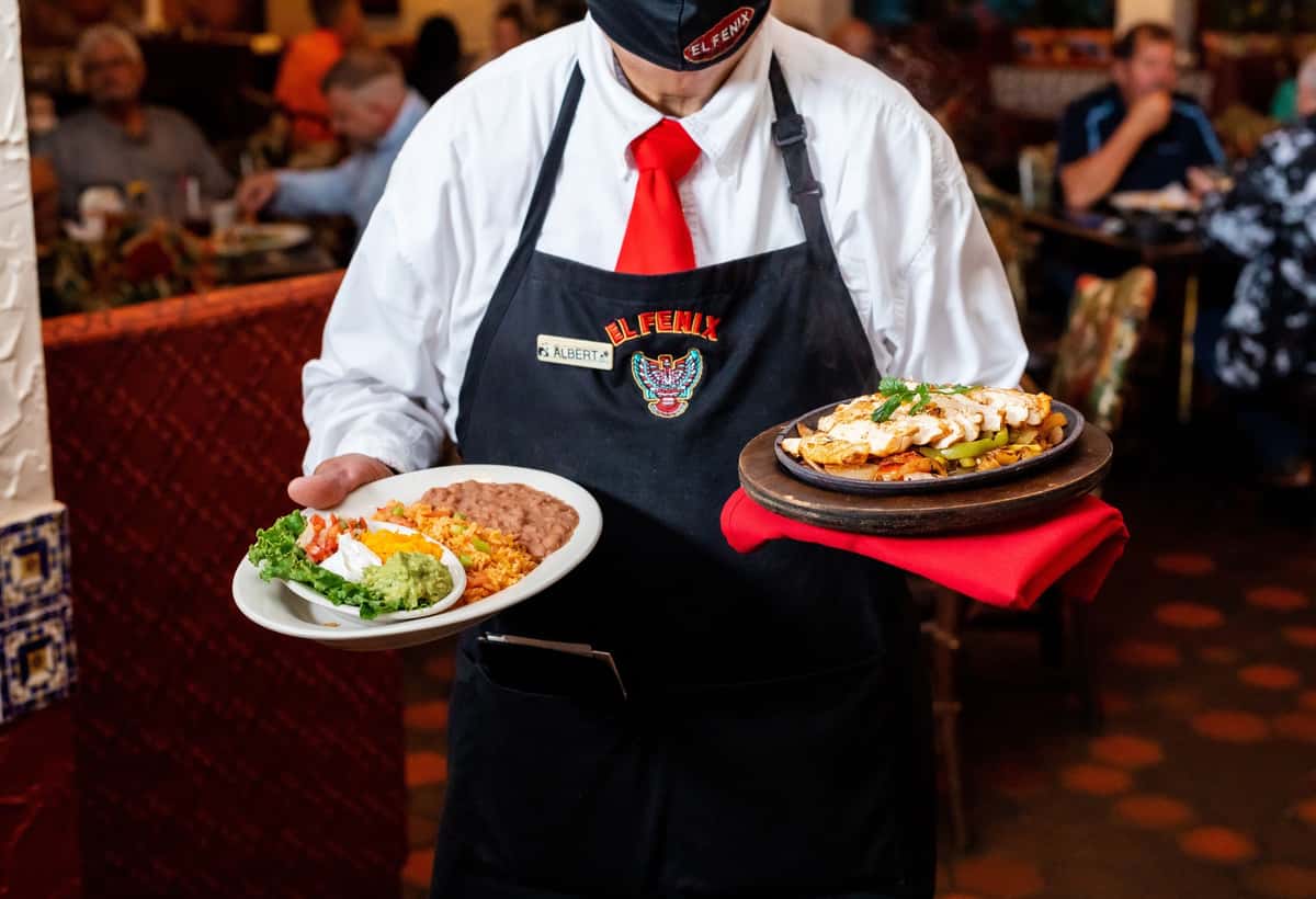 waiter holding mexican food dishes