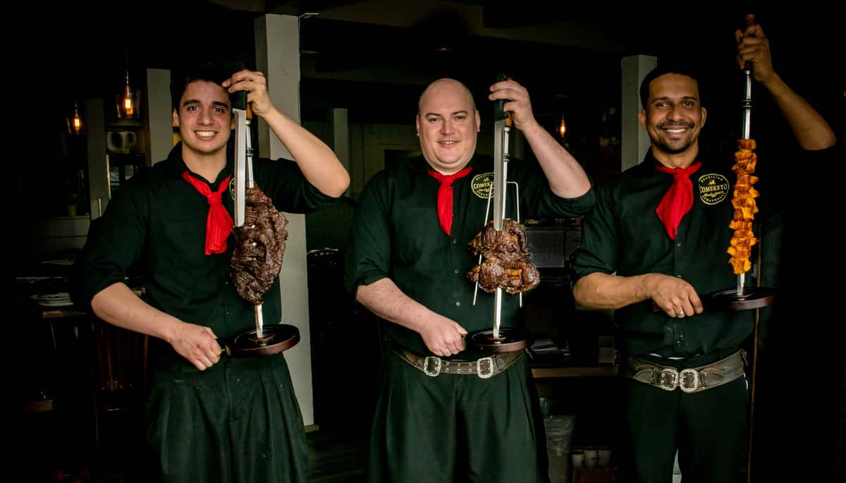 gauchos holding meat skewers