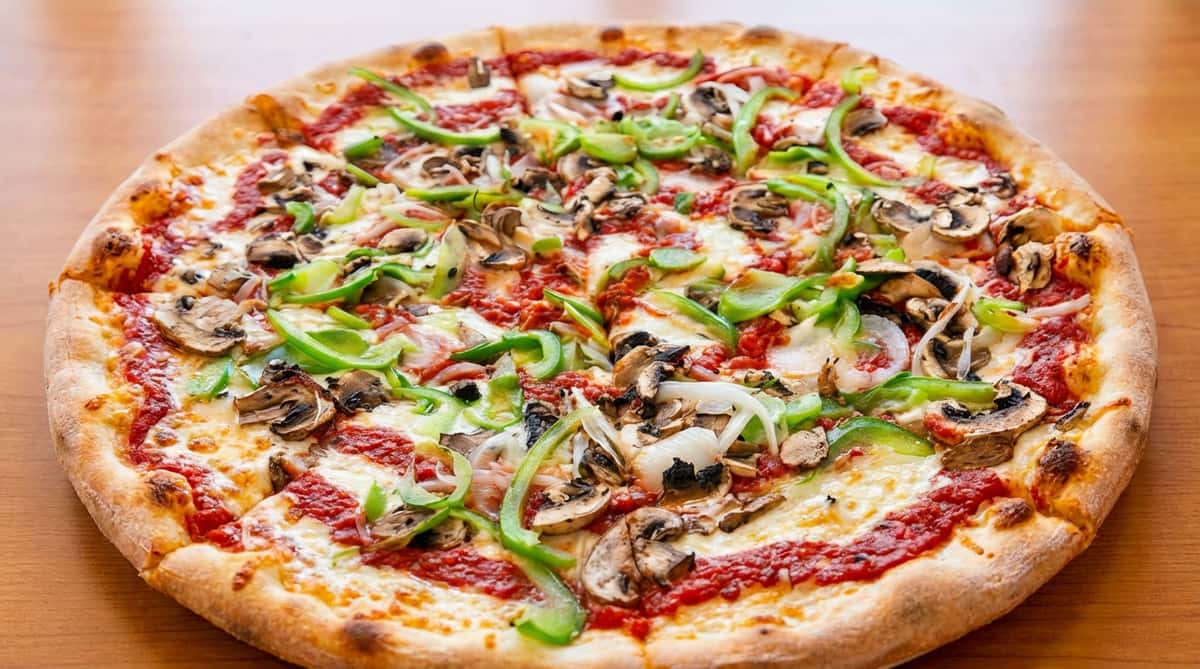 Half-and-half pizza with green peppers, mushrooms, and onions on one side, and plain cheese on the other.