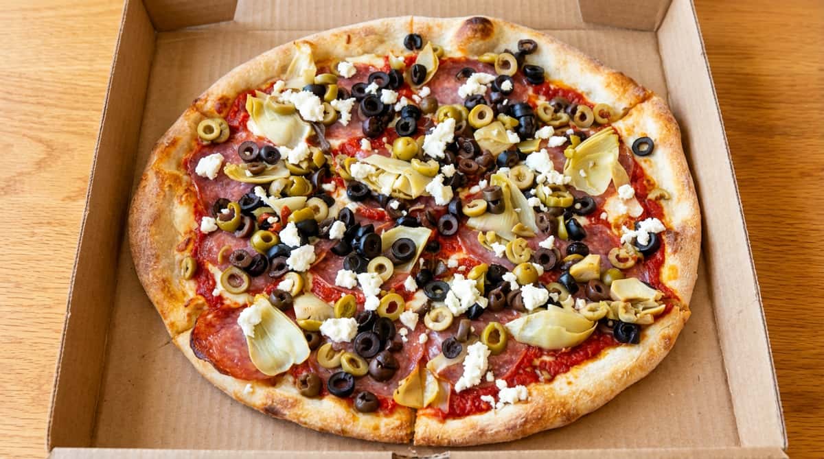 Pizza with pepperoni, black olives, green olives, artichoke hearts, and feta cheese.