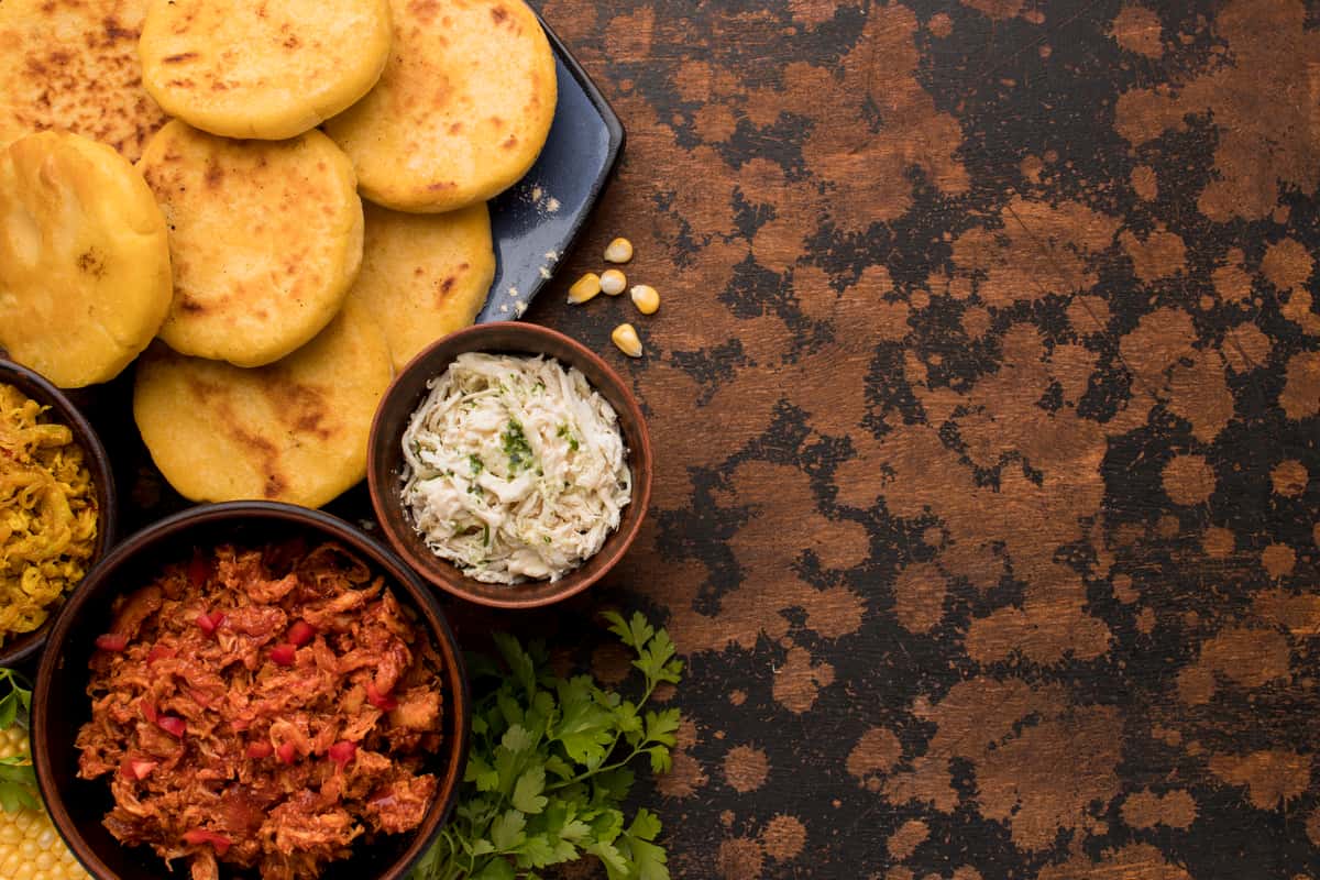 Bandeja con variedad de comidas latinas y arepas