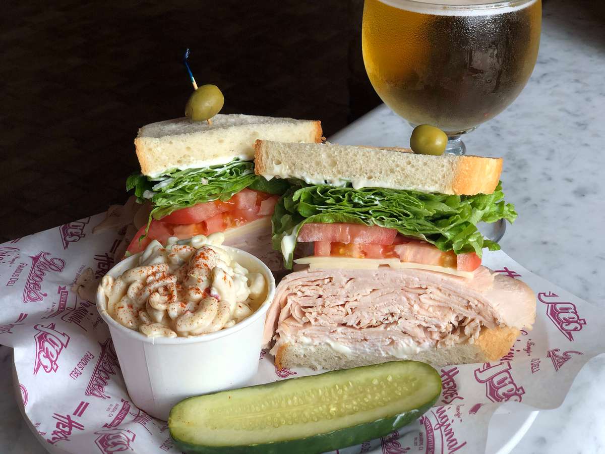 Turkey Sandwich with pasta salad, pickle and beer