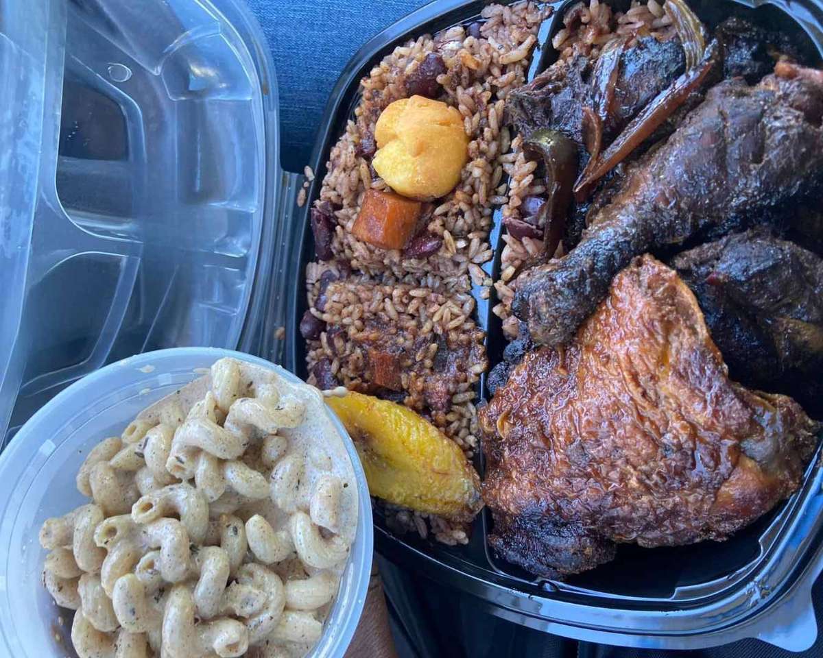 Jamaican combo plate with jerk chicken, fried chicken, rice and peas, fried plantain, festival, and creamy pasta salad on the side.