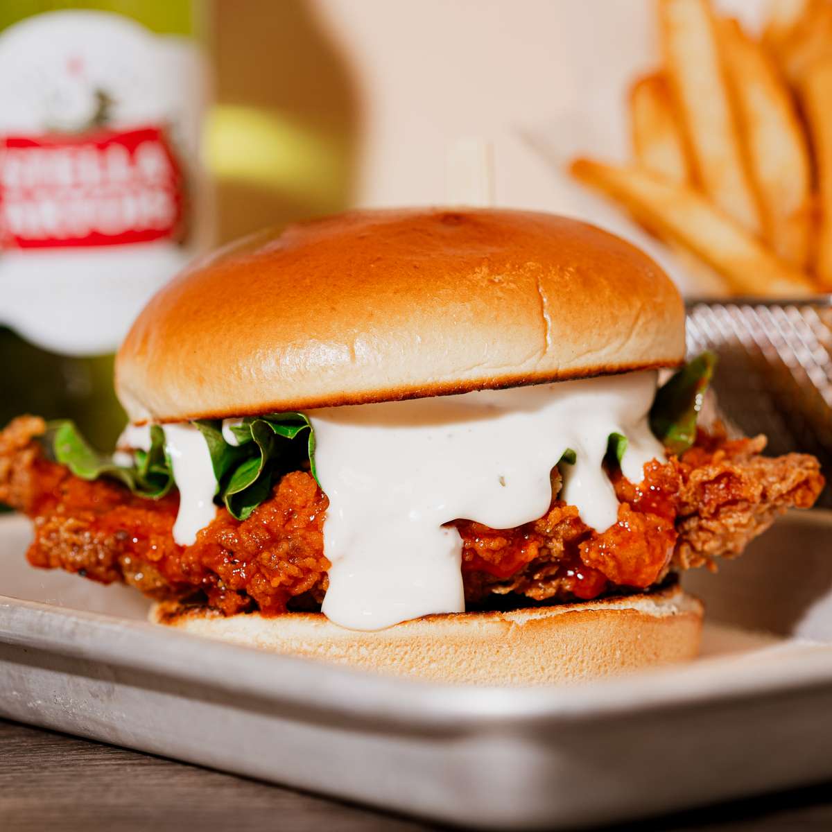 A golden-brown fried chicken breast topped with buffalo sauce and ranch