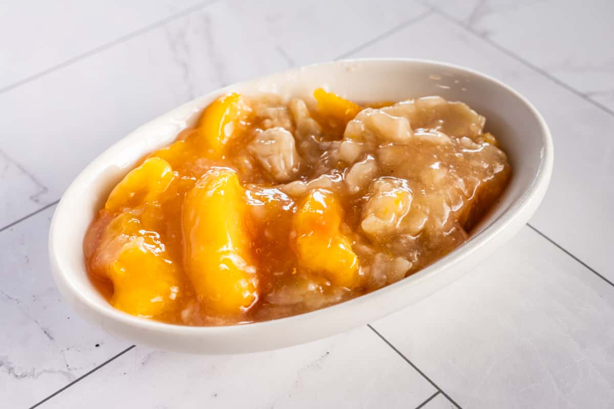 sweet mango dessert with sticky rice and coconut sauce in a small dish, classic Thai dessert with rich tropical flavors
