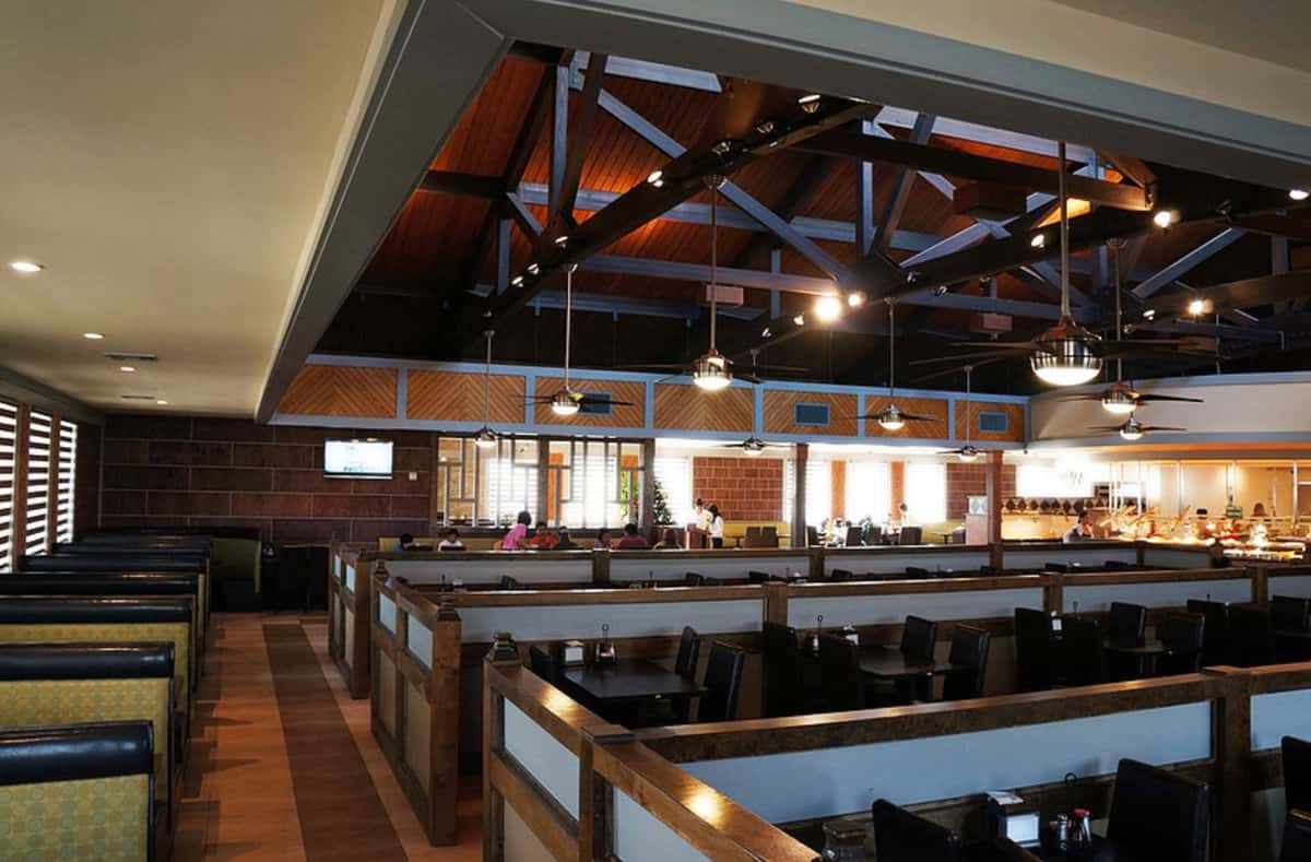 Interior of a building with wooden booths and wooden ceiling with lights that are hanging from wooden beams
