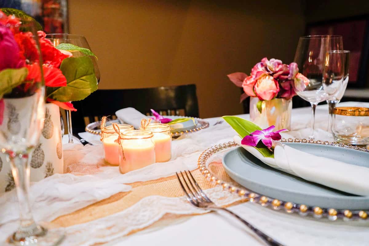 elegant restaurant table setting with candles, floral centerpieces, wine glasses, and neatly arranged plates for a romantic dining experience