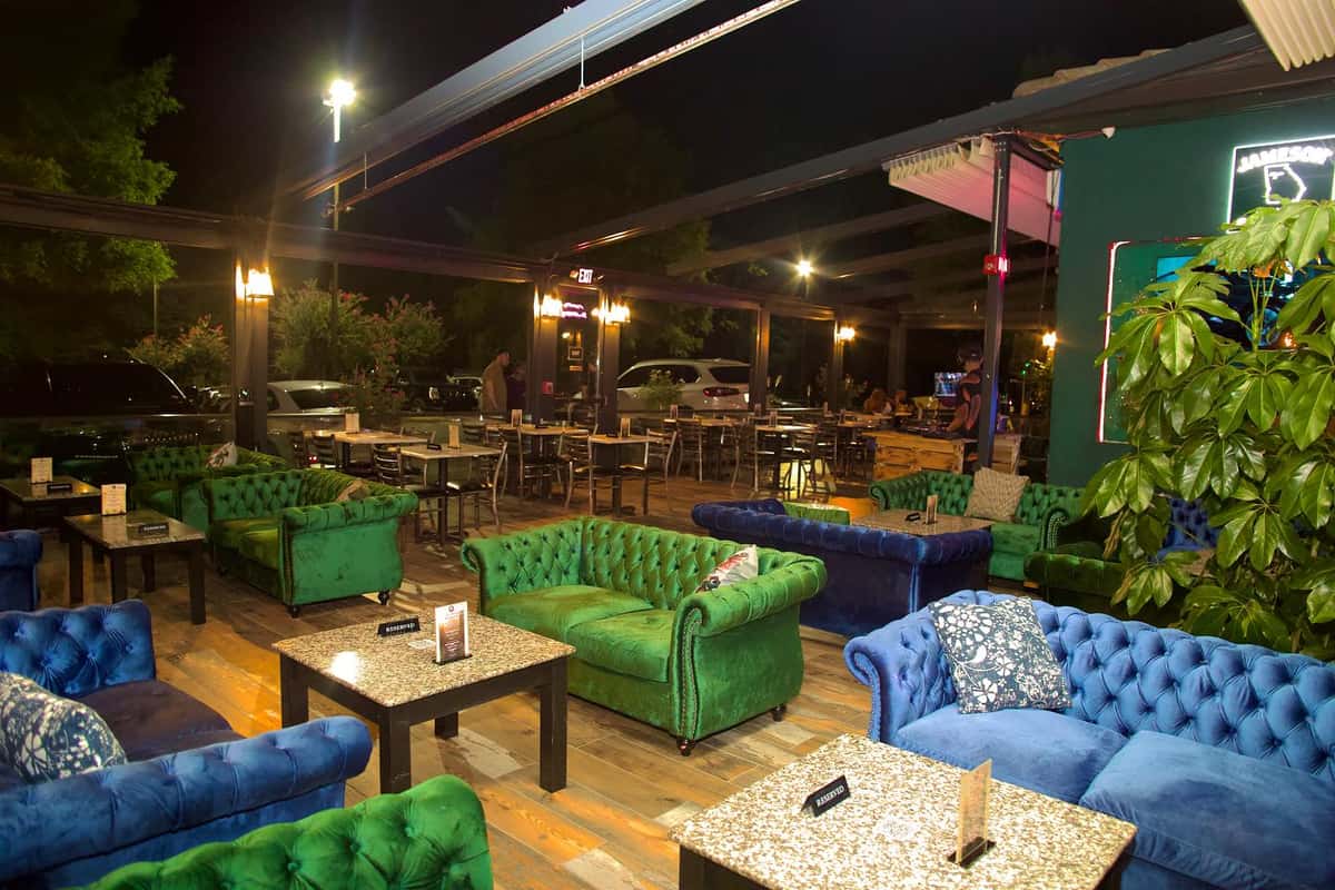 Outdoor patio seating at Sivas Tavern with stylish lounge furniture and vibrant nighttime dining atmosphere