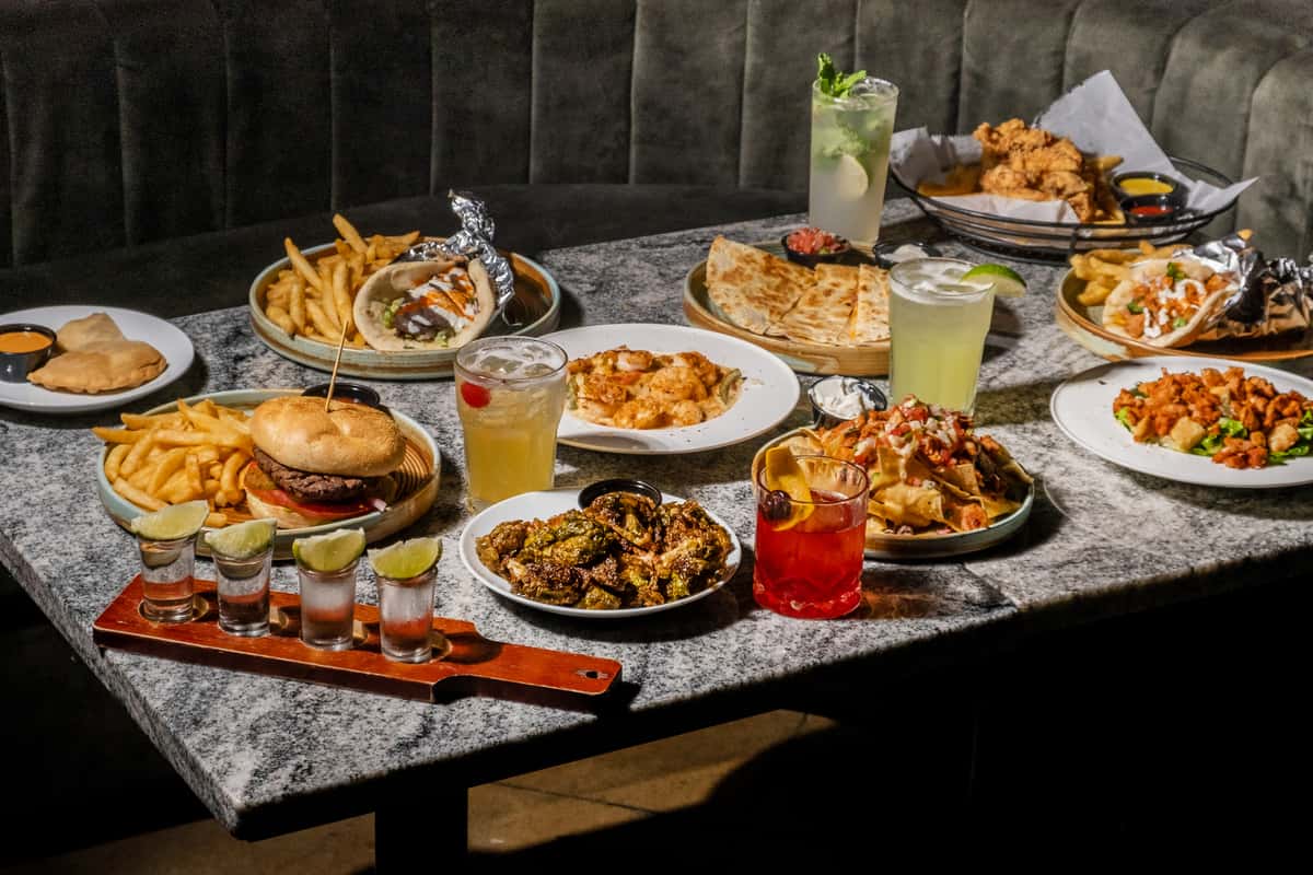A vibrant spread of Mediterranean dishes and cocktails on a dining table at Sivas Tavern