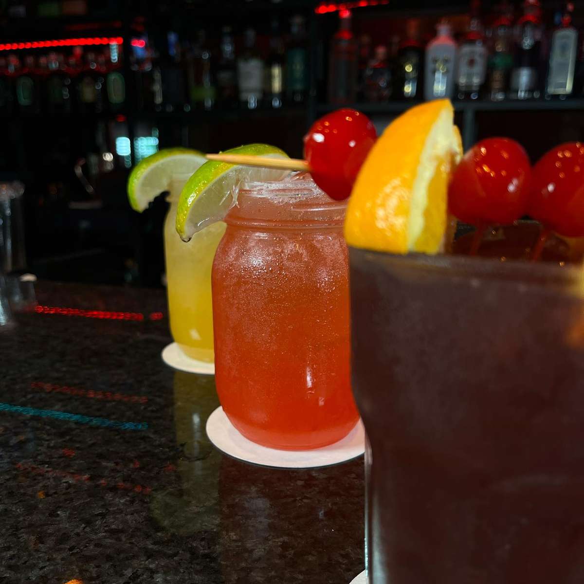 Colorful signature cocktails at Sivas Tavern bar with fresh fruit garnishes and vibrant lounge atmosphere