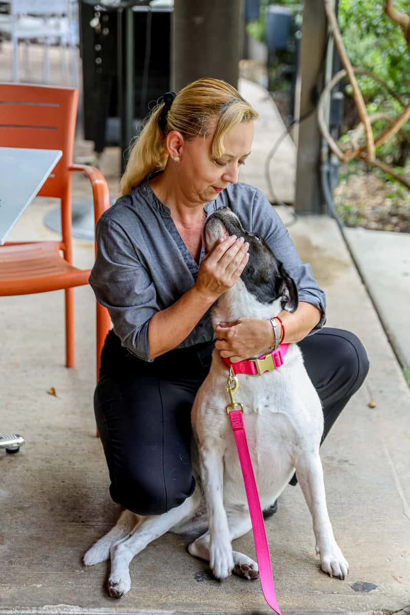 Glass & Vine staff member greeting a dog on the outdoor patio