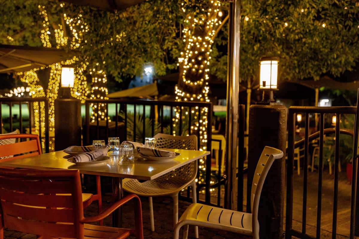 Cozy outdoor dining area with ambient lighting and a romantic atmosphere for an anniversary celebration.