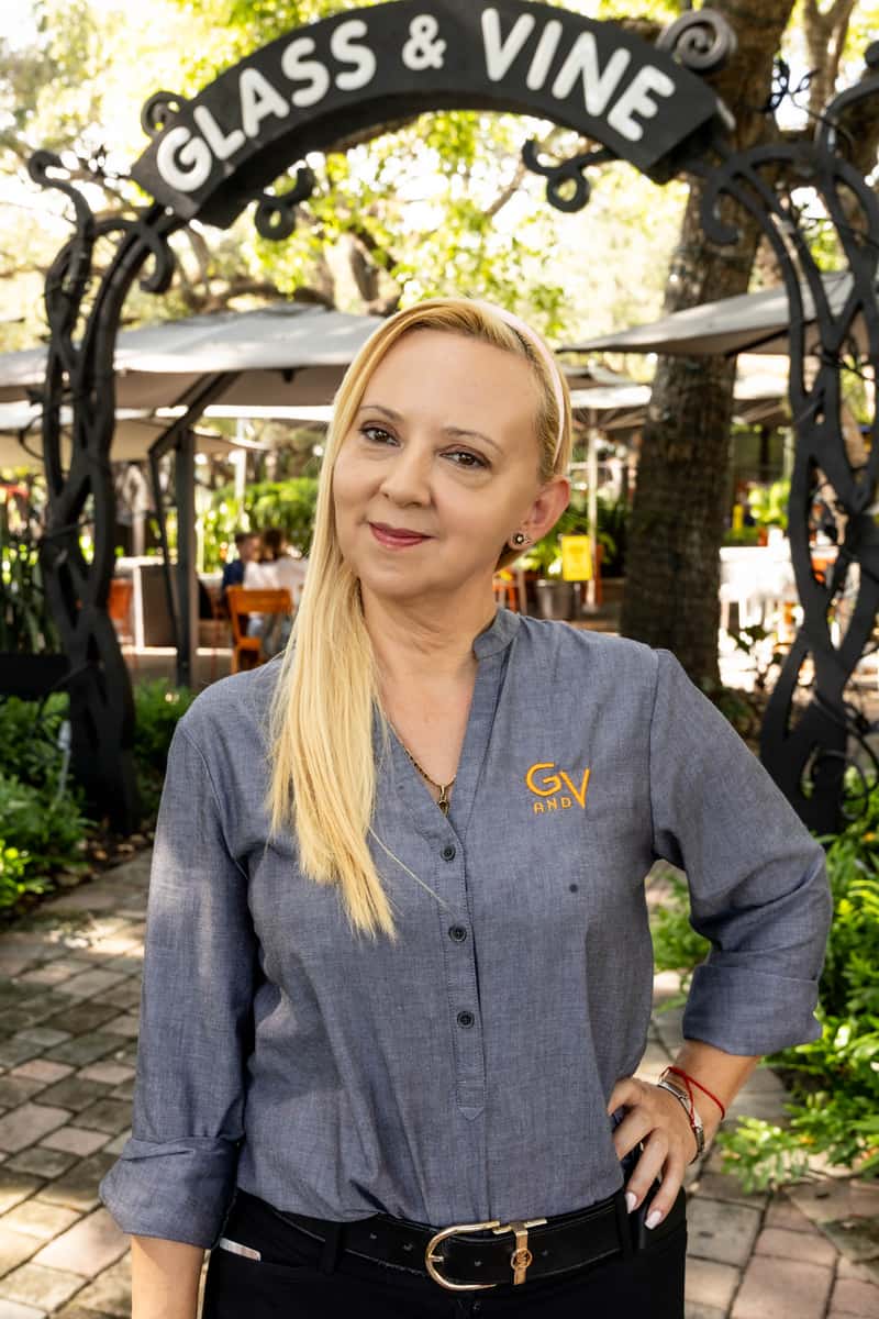 Glass & Vine staff member standing under the restaurant entrance in Coconut Grove