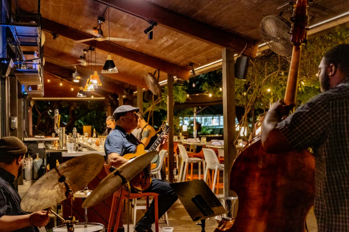 Live jazz musicians performing on the Glass & Vine outdoor patio during an evening gathering