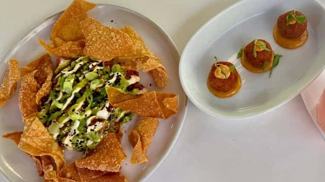 Glass & Vine's signature Tuna Tartare dish with crispy wonton and avocado garnish