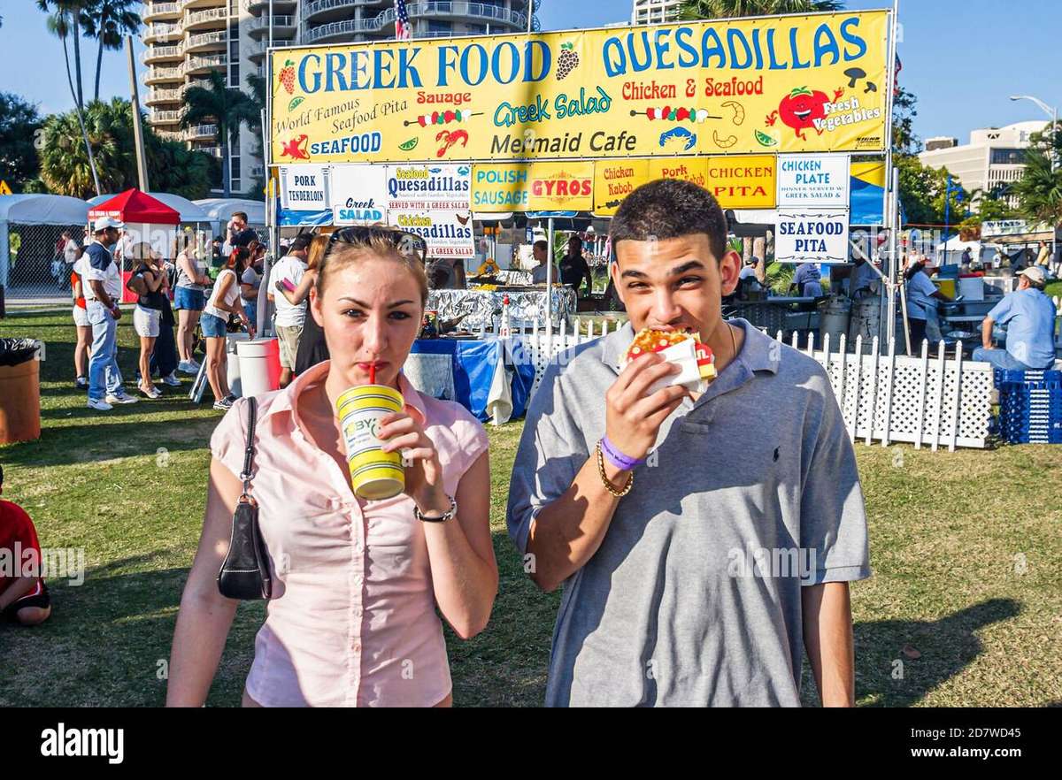 Food vendor stalls at the Coconut Grove Arts Festival with visitors browsing options