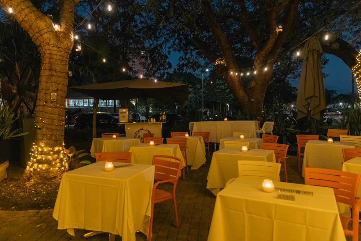 Private outdoor restaurant seating arranged under string lights for a party
