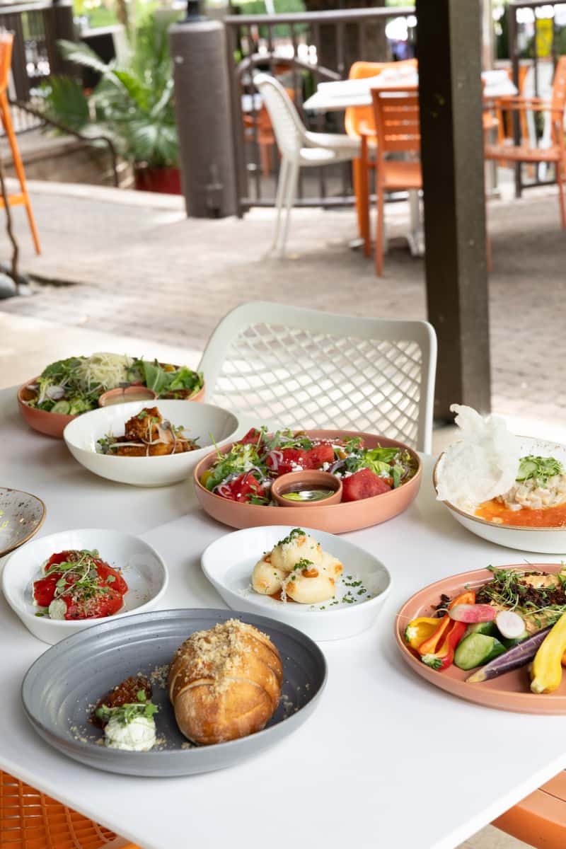 Glass & Vine brunch dishes with eggs, berries, and savory plates on an outdoor table