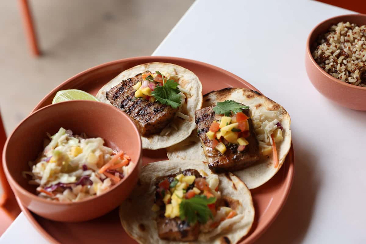 Grilled fish tacos with slaw, salsa, lime, and rice served at Glass & Vine
