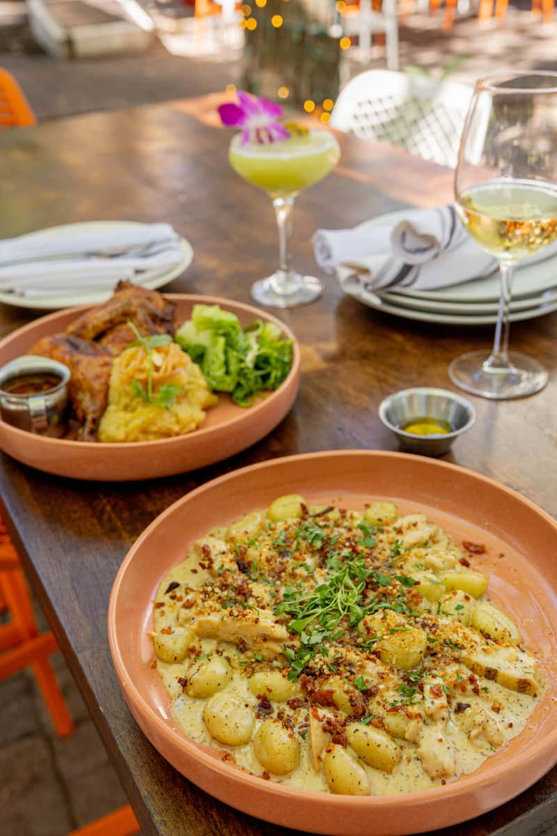 Glass & Vine patio table with creamy gnocchi, roasted chicken, cocktails, and wine