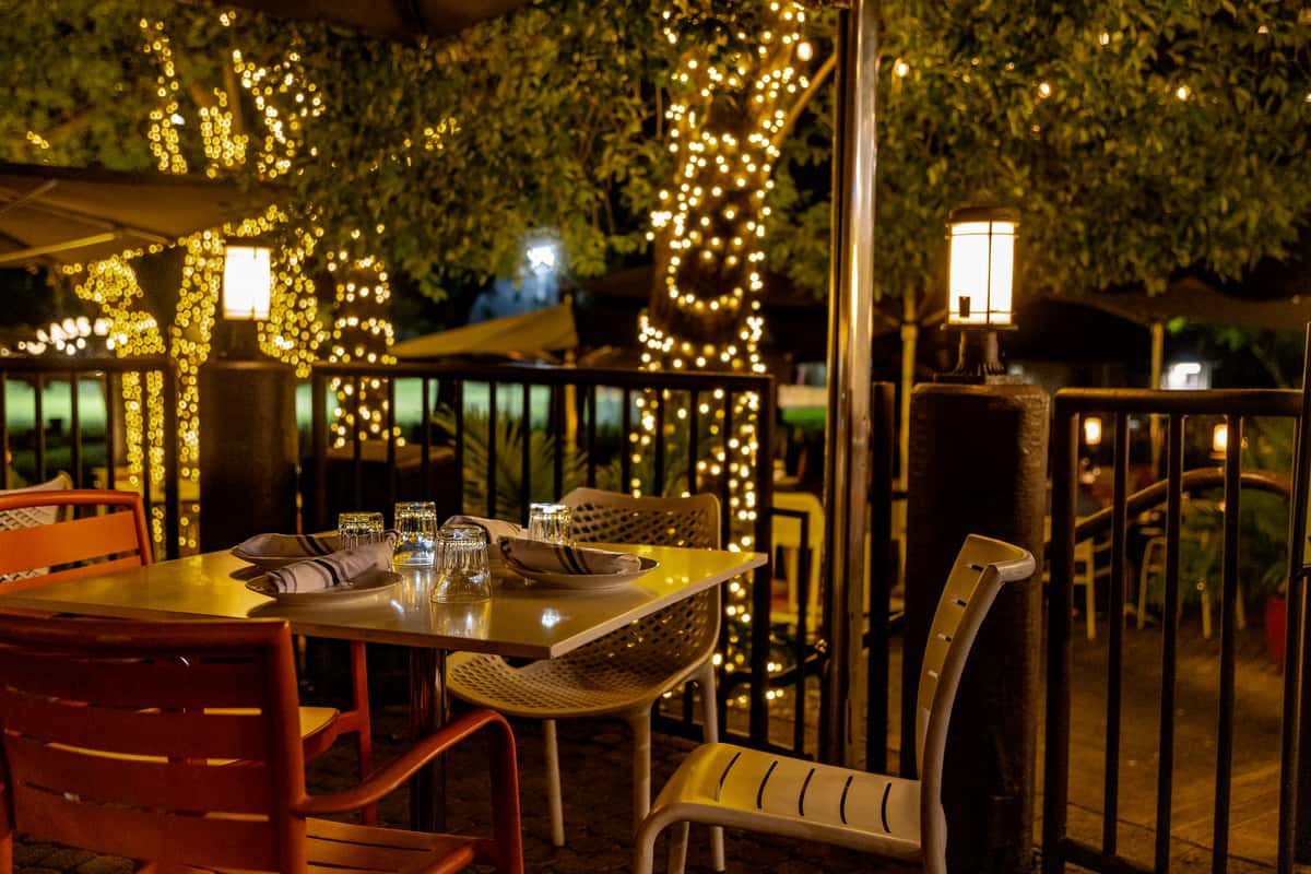 Glass & Vine outdoor patio table set at night under warm string lights