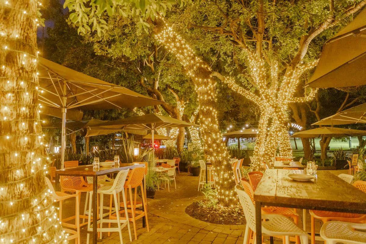 String-lit outdoor dining patio at Glass & Vine set up for a relaxed evening event