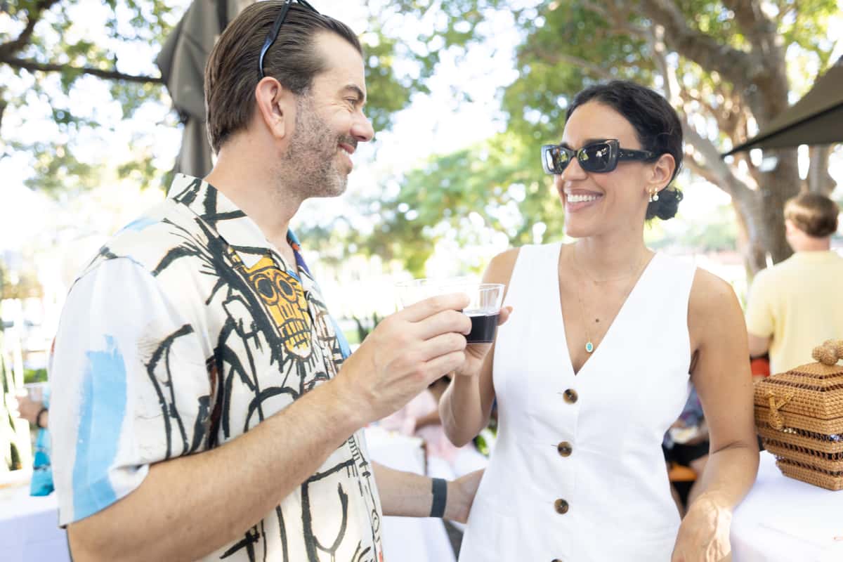 Couple enjoying drinks together at an outdoor cocktail party engagement