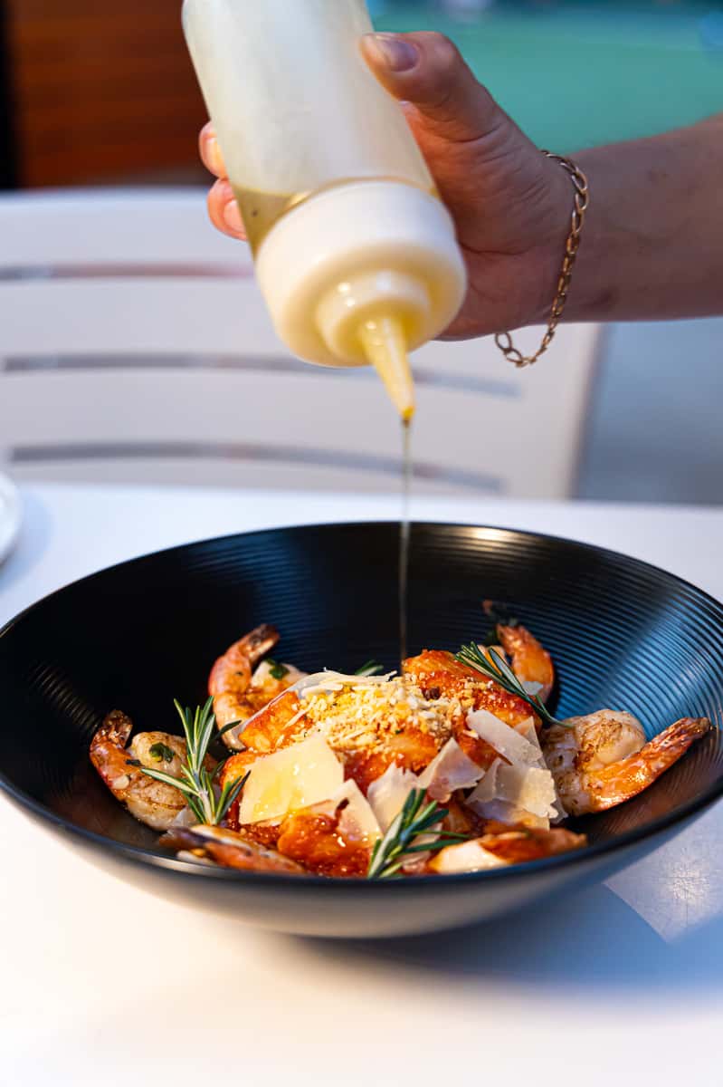 Server adding dressing to a salad