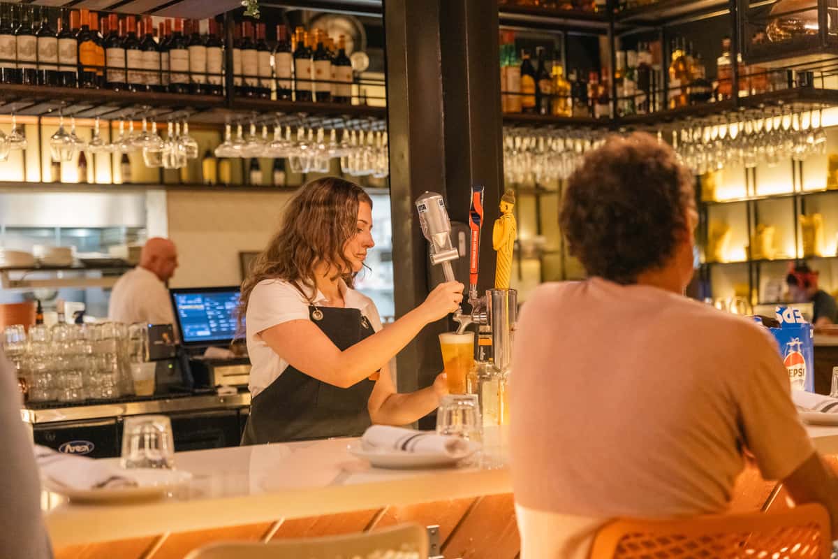 Bartender serving drinks at a restaurant bar during a private party.