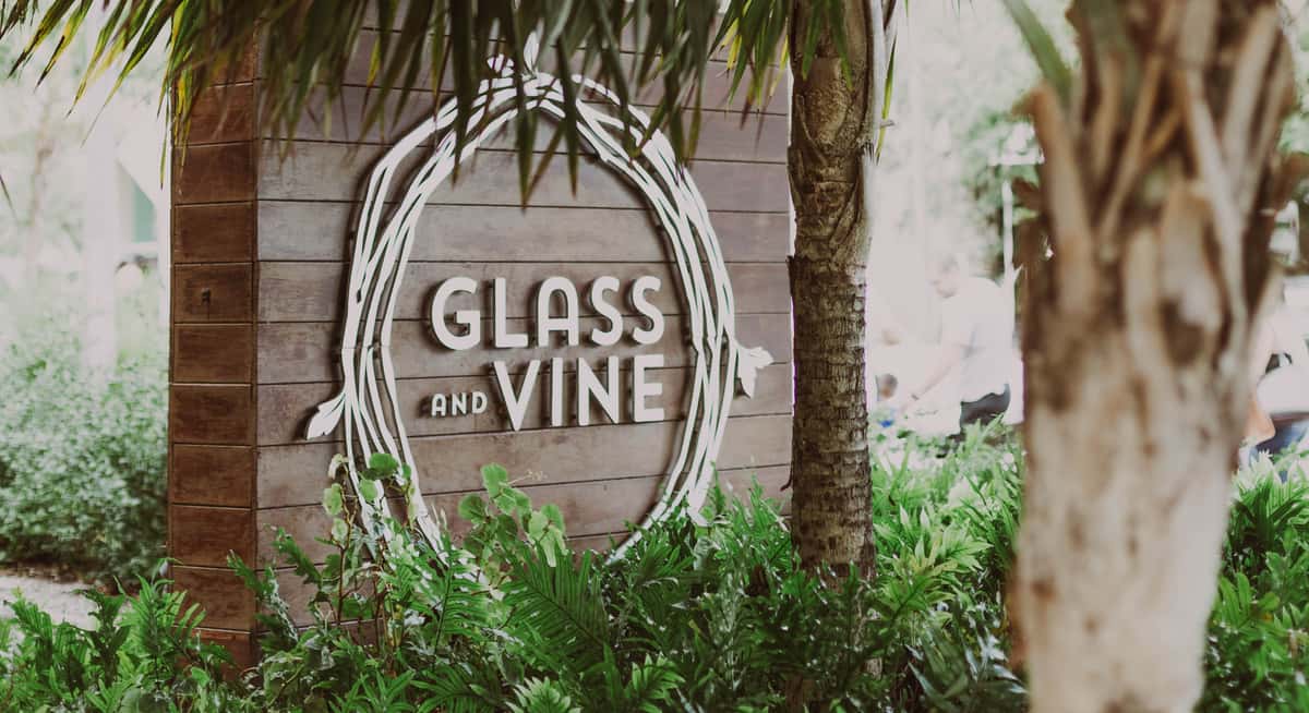 Glass & Vine restaurant sign surrounded by lush tropical greenery in Coconut Grove, Miami