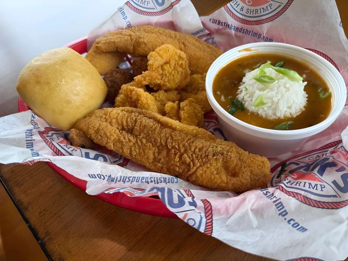 Fried seafood platter with fish, shrimp, hush puppies, coleslaw, and gumbo.