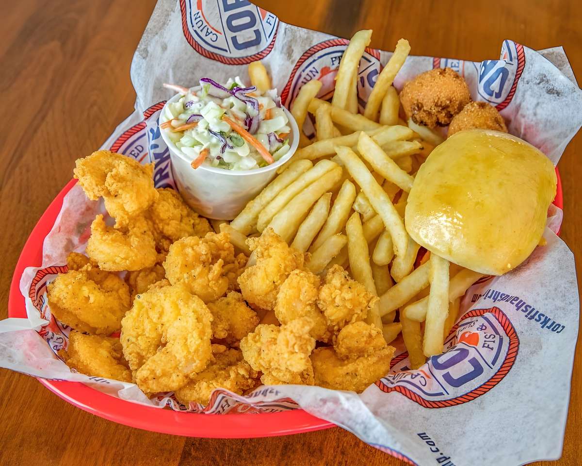Fried shrimp basket served with French fries, hush puppies, coleslaw, and bread.