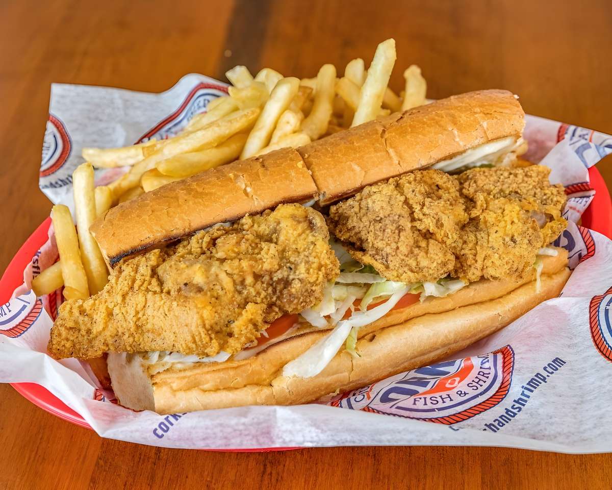 Fried seafood po' boy sandwich served with French fries.
