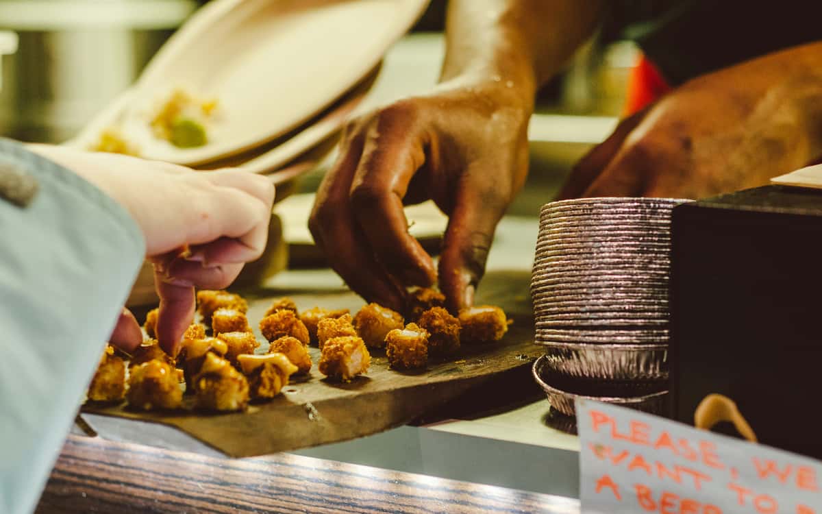 Owner and customer getting hands on with freshly made food