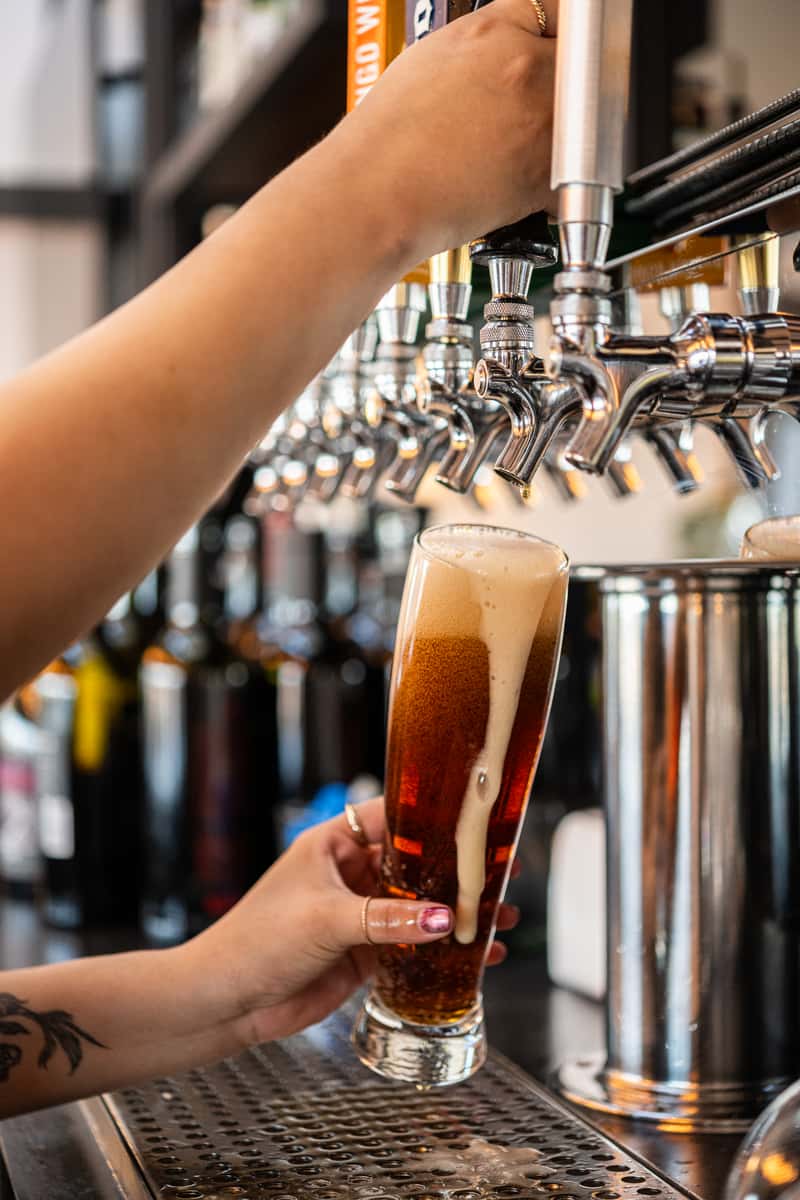 Bartender's hands pouring a beer from a tap
