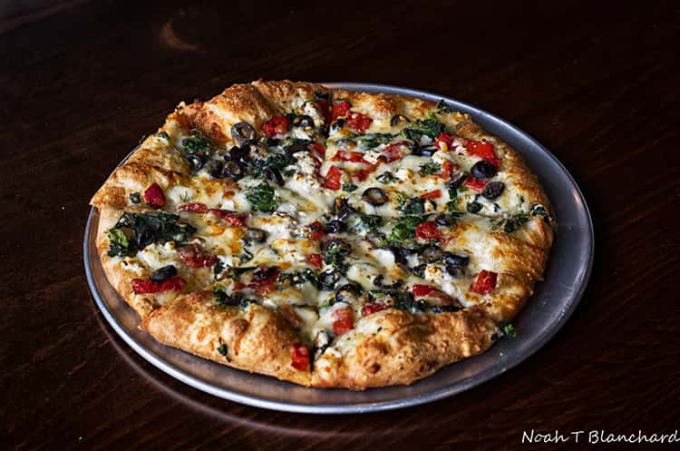 Pizza with olives, tomatoes and spinach