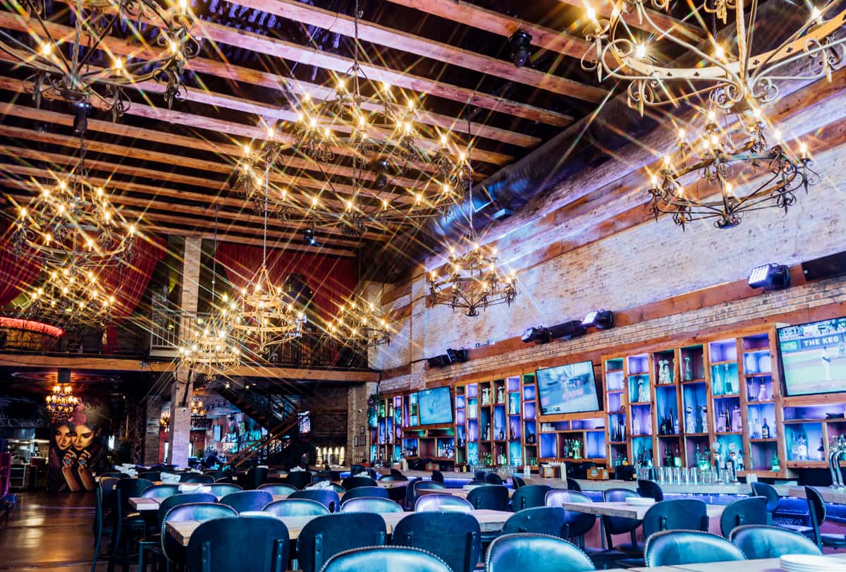River North interior room with wide screen TV's, exposed rafters and large candle lit chandeliers.